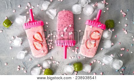Summer Heat: Refreshing Pink Fruit Ice Cream Ith Strawberry Pieces Surrounded By Transparent And Gre