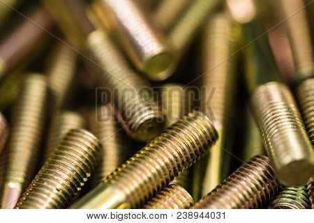 Close-up Glossy Brass Bolts Background. Brand New Stainless Screws Or Fastener. Industrail Abstract 