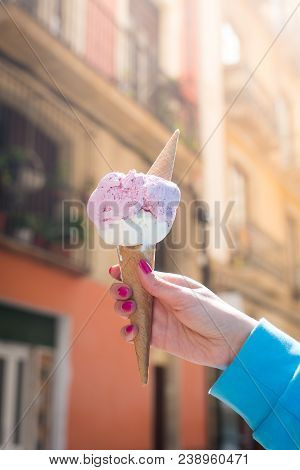 A Woman Sitting And Holding An Ice Cream. Summer Time In The Street Of The Old City
