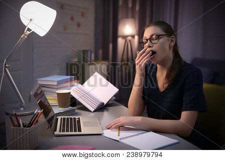 Tired student doing homework indoors late at night