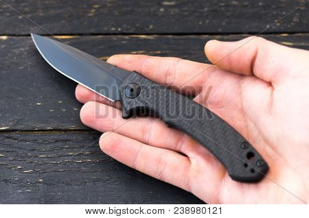 Black Pocket Knife In Hand. Knife In The Right Hand.