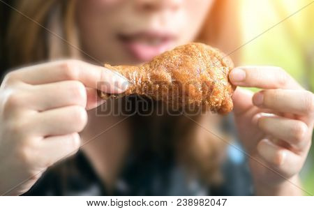 Woman With Opening Mouth About To Eat Deep Fried Chicken Legs.