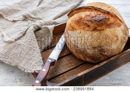 Handmade Tartine Bread Loaf In A Wooden Box On A White Table With Linen Cloth, Selective Focus.