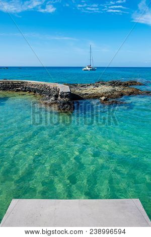 Catamaran Anchored Offshore In The Beautiful Blue Waters Of Mauna Lani Bay On The Big Island Of Hawa