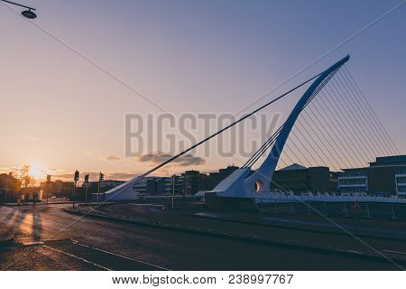 View Of Dublin's Famous Samuel Beckett Bridge Over The River Liffey At Sunset