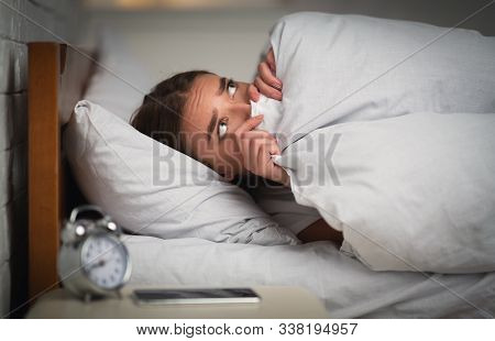 Anxiety And Insomnia. Scared Girl Lying In Bed Unable To Get To Sleep Pulling Blanket Over Face At H