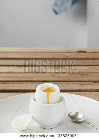 Soft-boiled Egg, White Egg On A Wooden Brown Table. White Ceramic Plate With Soft-boiled Egg. Mornin