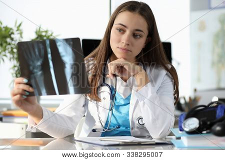 Portrait Of Concentrated Surgeon At Clinic Office. Specialist With Stethoscope Holding Radiograph Of