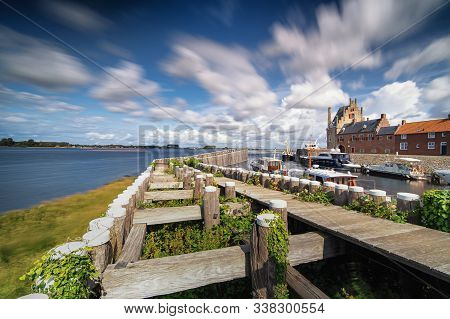 Dynamic Moving Exaggerated White Clouds Against A Blue Sky Above A Dutch Lake Near An Old Seaport