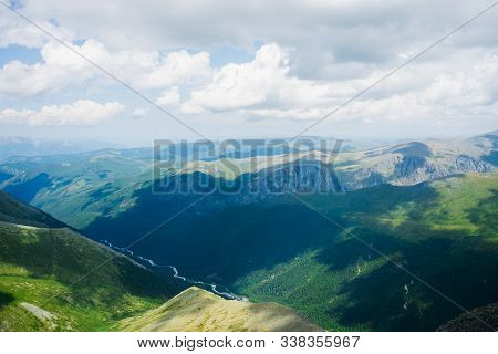 Aerial Tranquil View To Scenic Long Valley With Mountain River And Forest. Shadows Of Clouds On Mass