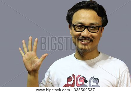 A Smiling And Confident Manipuri North East Indian Man With Spectacles Showing The Sign Of Five With