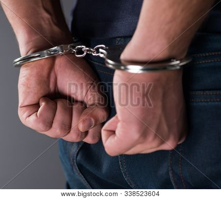 Man with his hands handcuffed in criminal concept