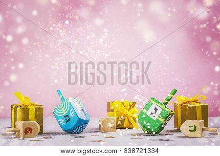 Happy Chanukah Background With Gift Boxes And Dreidel Spinnners On Pink. Space For Text