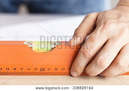 Craftsman Measuring A Plank Of Wood With A Spirit Level