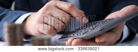 Close-up Of Accountants Hands Calculating Profit. Staircase Of Coins On Desktop. Businessman Plannin