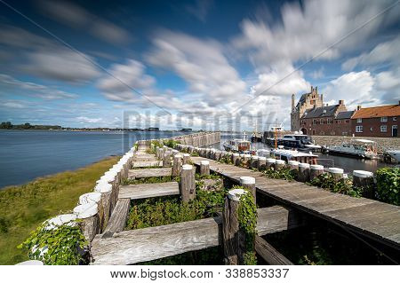 Dynamic Moving Exaggerated White Clouds Against A Blue Sky Above A Dutch Lake Near An Old Seaport