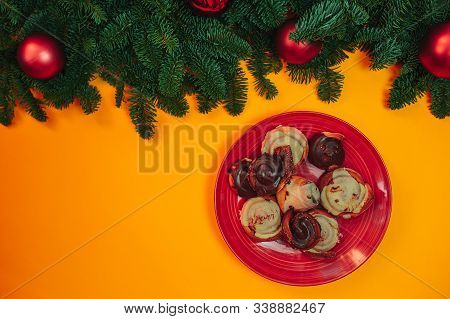 Natural Fir Branches Flat Lay With Christmas Ornaments On The Orange Background. Christmas Card With
