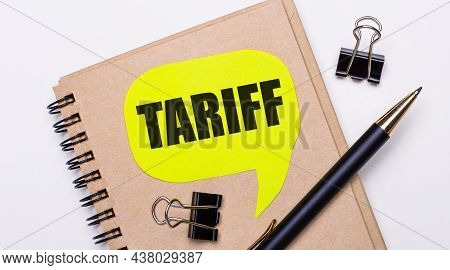 On A Light Background, A Brown Notebook, A Black Pen And Paper Clips, And A Yellow Card With The Tex