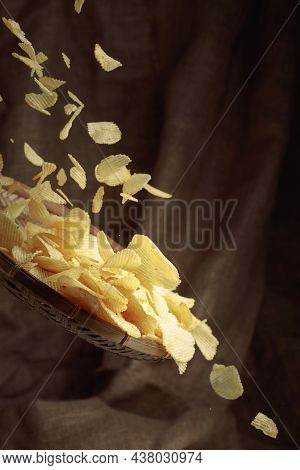 Falling Potato Chips On The Background Of Burlap. Copy Space.