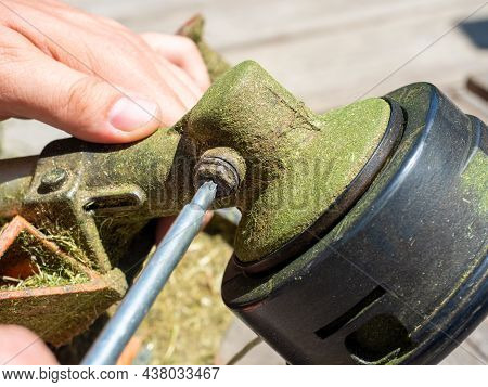 Close-up Of Unscrewing The Screw On The Trimmer Gearbox For Mowing Grass With A Special Key. Equipme