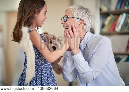 A cheerful grandma is so happy while spending a wonderful time with her granddaughter in a family atmosphere at home. Family, home, love, playtime