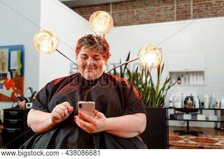 Woman browsing her phone at a salon