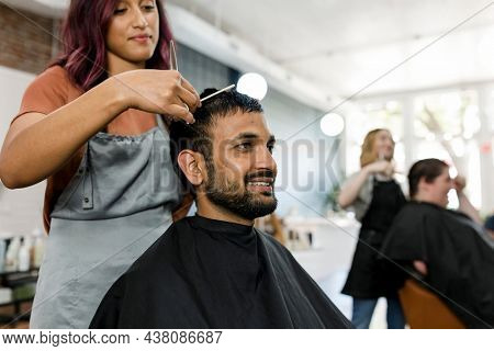 Man getting a haircut from a hair stylist at a barber shop