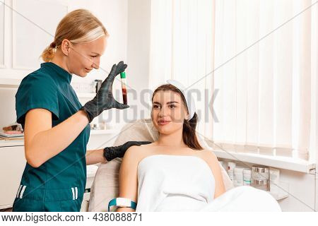Plasmolifting. Cosmetologist Shows A Tube With Blood To The Client. Preparation For Rejuvenation Inj