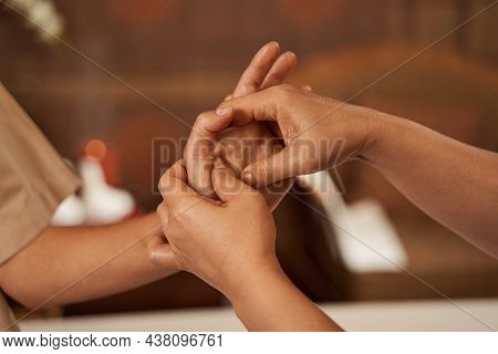 Spa Therapist Massaging Acupoints On Client Hand