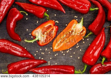 Halves Of The Fresh Bell Pepper Red And Orange Colors Cut Lengthwise Lies On The Dark Surface Among 