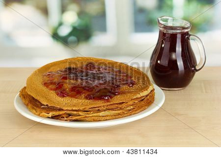 หวาน pancakes บนแผ่นกับแยมบนโต๊ะในห้องครัว