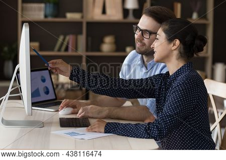 Happy Young Indian Employee Working On Online Project With Colleague.