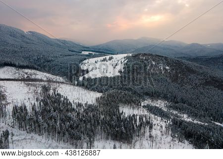Aerial Winter Landscape With Spruse Trees Of Snow Covered Forest In Cold Mountains In The Evening.