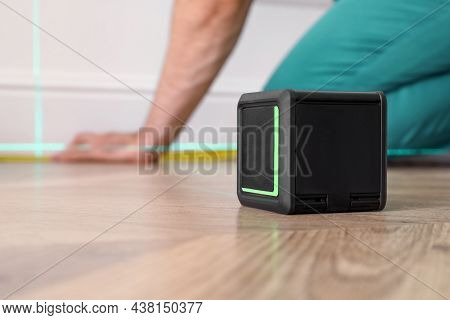 Cross Line Laser Level On Wooden Floor Indoors