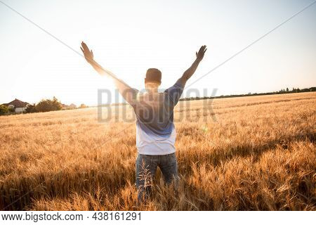 Unspecified Man With Hands Up Watching Sunset