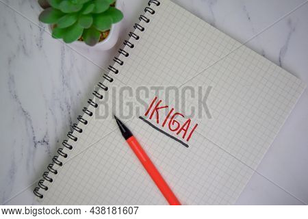 Ikigai Write On A Book Isolated On Wooden Table.