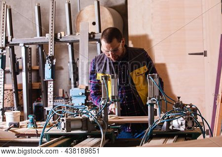 Professional Carpenter Working At Woodwork Factory With Pneumatic Press