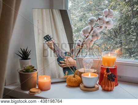 Girl Sits In Her Room On A Window Sill Decorated For The Holiday And Plays The Ukulele. Her Reflecti