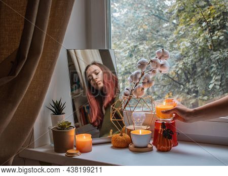 Girl Decorates The Window Sill In Her Room For The Holiday. She Made A Composition Of Mirror, Flower
