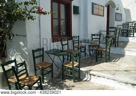 Beautiful Amorgos Island, Greece Traditional Taverna With Shaded Terrace Old Fashioned Tables And Ch