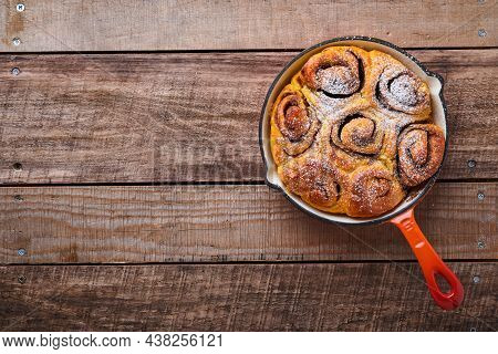 Cinnabon Cinnamon Rolls Buns With Pumpkin, Nut, Caramel And Sugar Cream Iced On Rustic Wooden Backgr