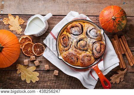 Cinnabon Cinnamon Rolls Buns With Pumpkin, Nut, Caramel And Sugar Cream Iced On Rustic Wooden Backgr