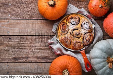 Cinnabon Cinnamon Rolls Buns With Pumpkin, Nut, Caramel And Sugar Cream Iced On Rustic Wooden Backgr