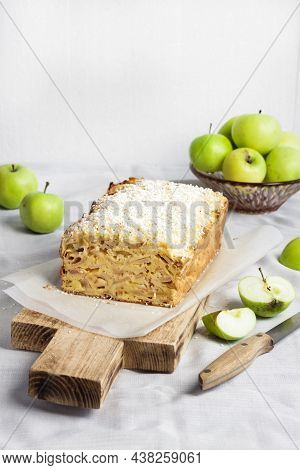 Apple And Coconut Oaf Cake On Wooden Cutting Board And Apples In A Vase
