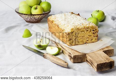 Apple And Coconut Oaf Cake On Wooden Cutting Board And Apples In A Vase