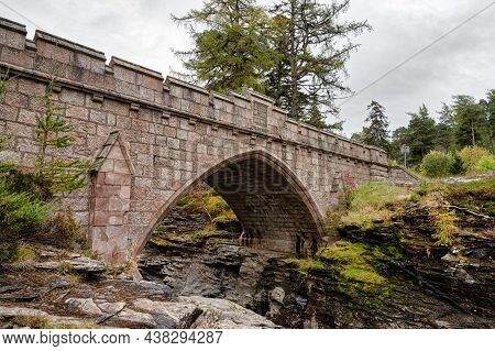 The Stone Bridge That Goes Over The Rapids Of The River Dee In The Cairngorms Mountains Of Scotland