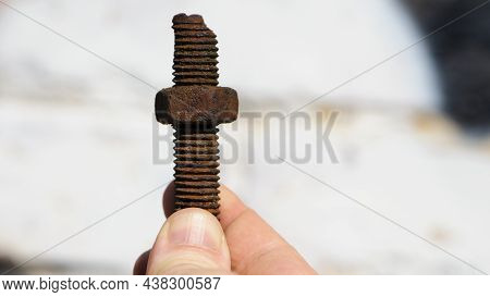 Old Rusty Bolt, Iron Rod With Screw Threads, In Hand. Rusted Mechanical Components. Holding Threaded