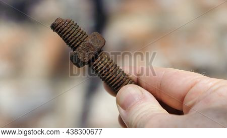 Old Rusty Bolt, Iron Rod With Screw Threads, In Hand. Rusted Mechanical Components. Holding Threaded