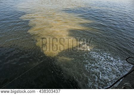 Dirty Orange Water From Sewage Pipeline Mixes With River Water.