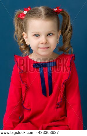 Close Up Portrait Of Lovely Little Blonde Girl. Charming Gray Eyed Cheerful Girl With Cute Two Ponyt